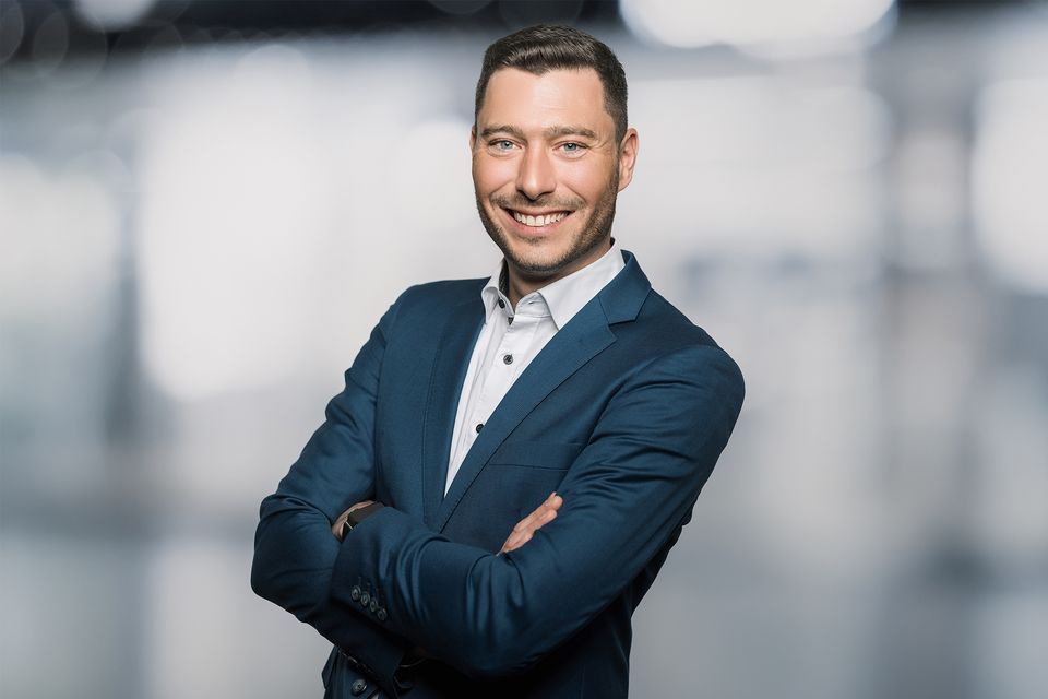 Businessportrait eines lächelnden Mannes im blauen Sakko