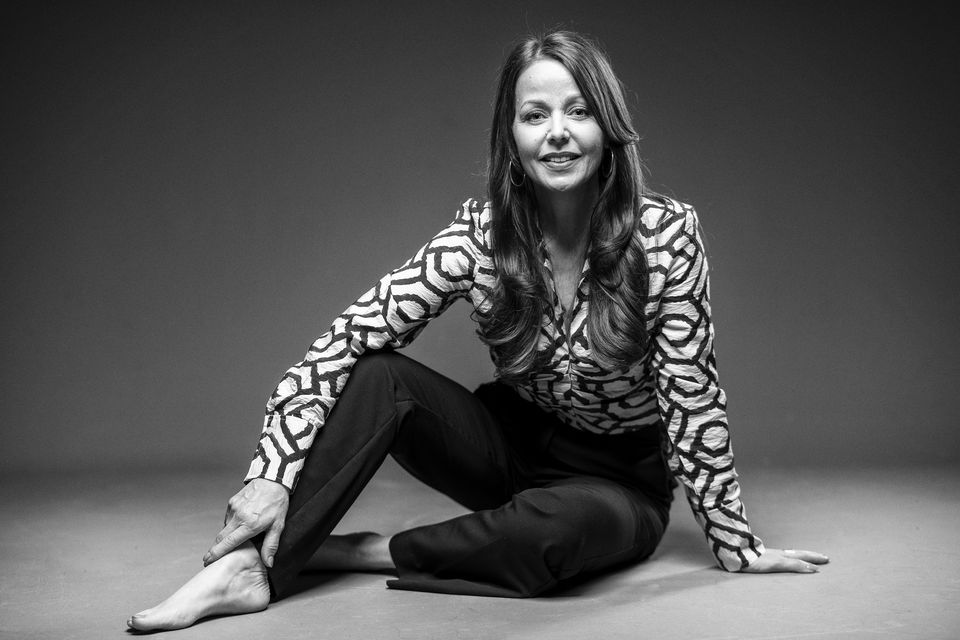 Studio-Portrait einer sitzenden Frau in Schwarzweiß