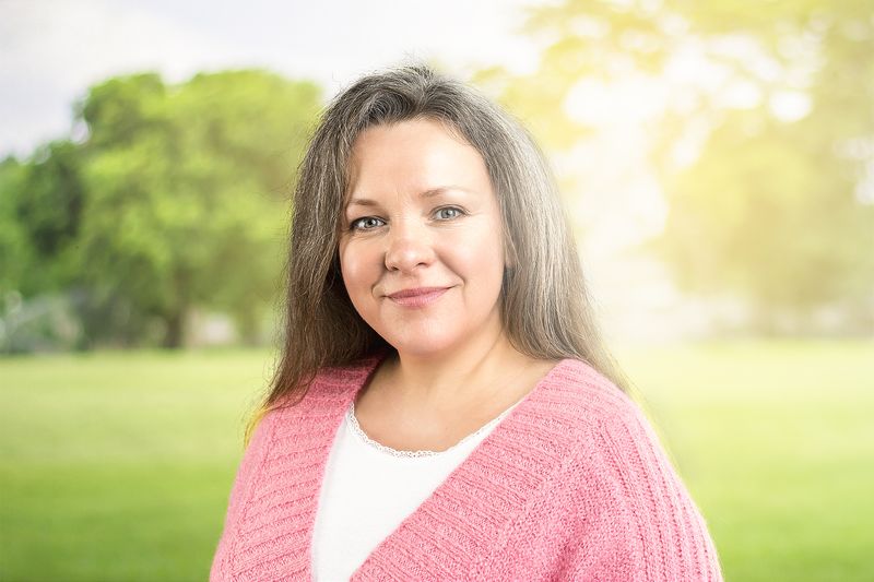 Frau in rosa Strickjacke im Grünen