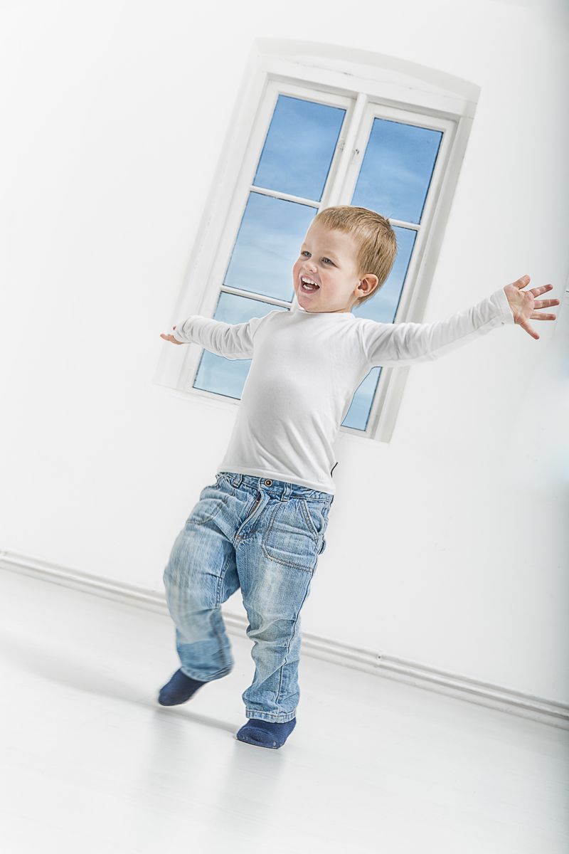 Junge springt vor einem Fenster