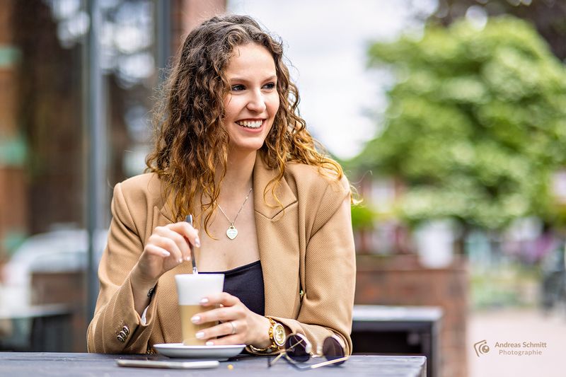 Lachende Frau mit Kaffee im Café