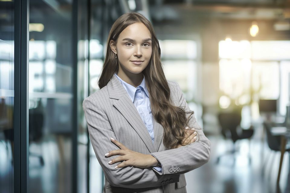 Junge Frau im grauen Blazer im Büro
