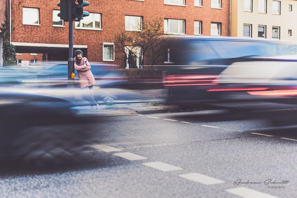 FRau auf Verkehrinsel in Hamburg mit vorbeifahrenden Autos