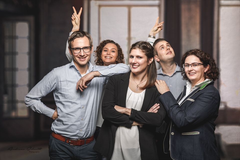 Familie lacht im Studio vor Holztüren