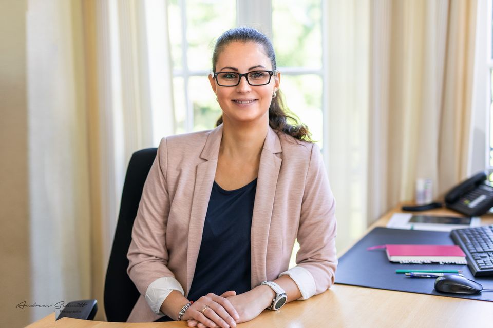 Frau sitzt am Schreibtisch im hellen Büro