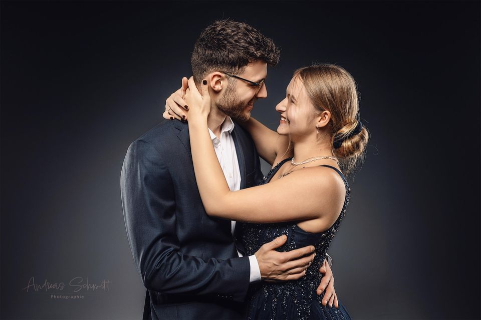 Paar umarmt sich im Anzug und Kleid