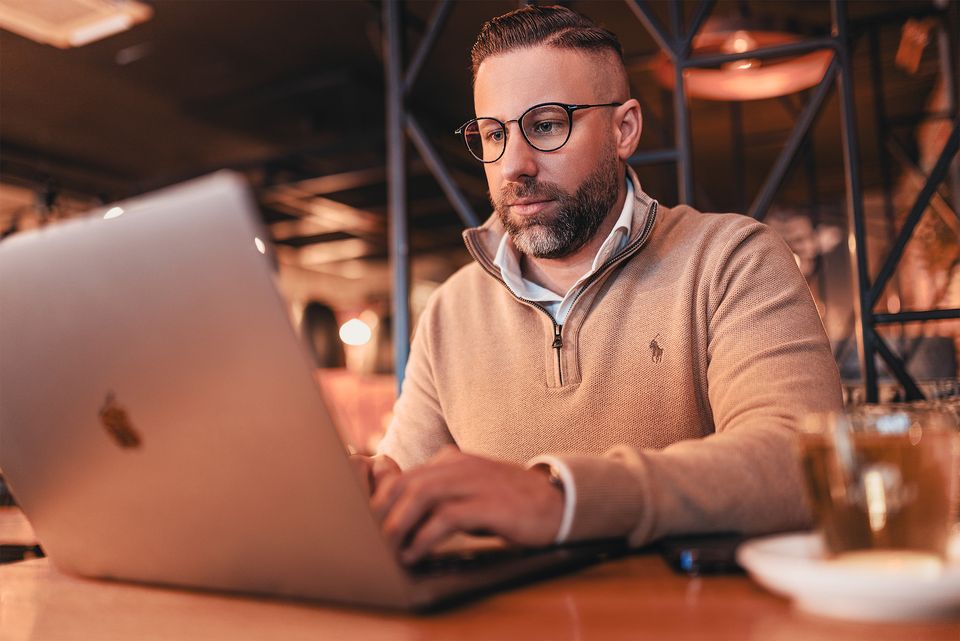 Mann arbeitet am Laptop in einer Halle